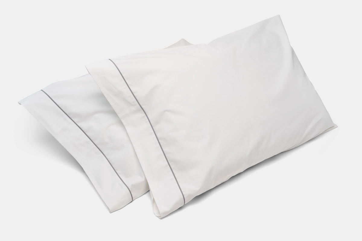 White cotton pillowcases with classic piping design, irregular style