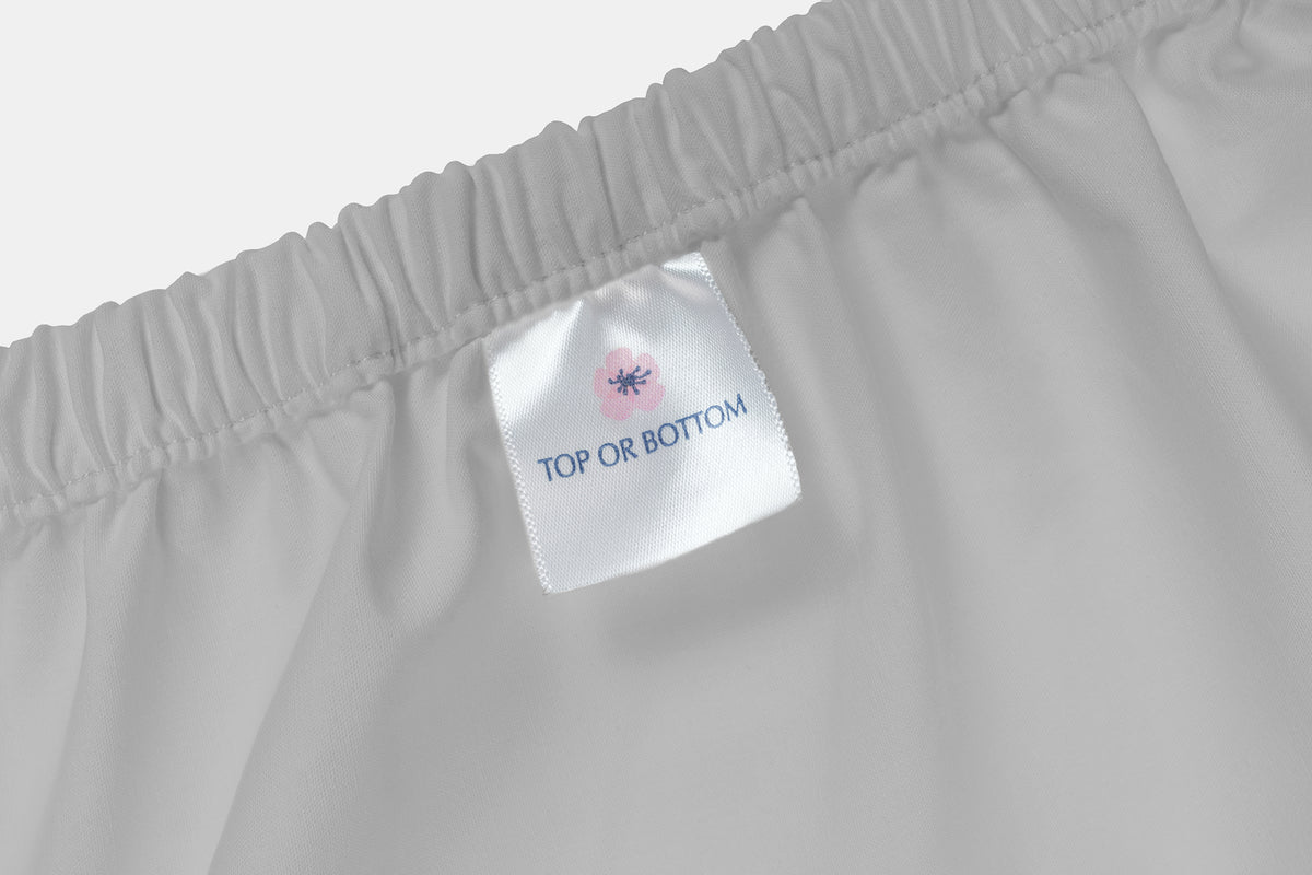 White bed sheet with elastic waistband and care label