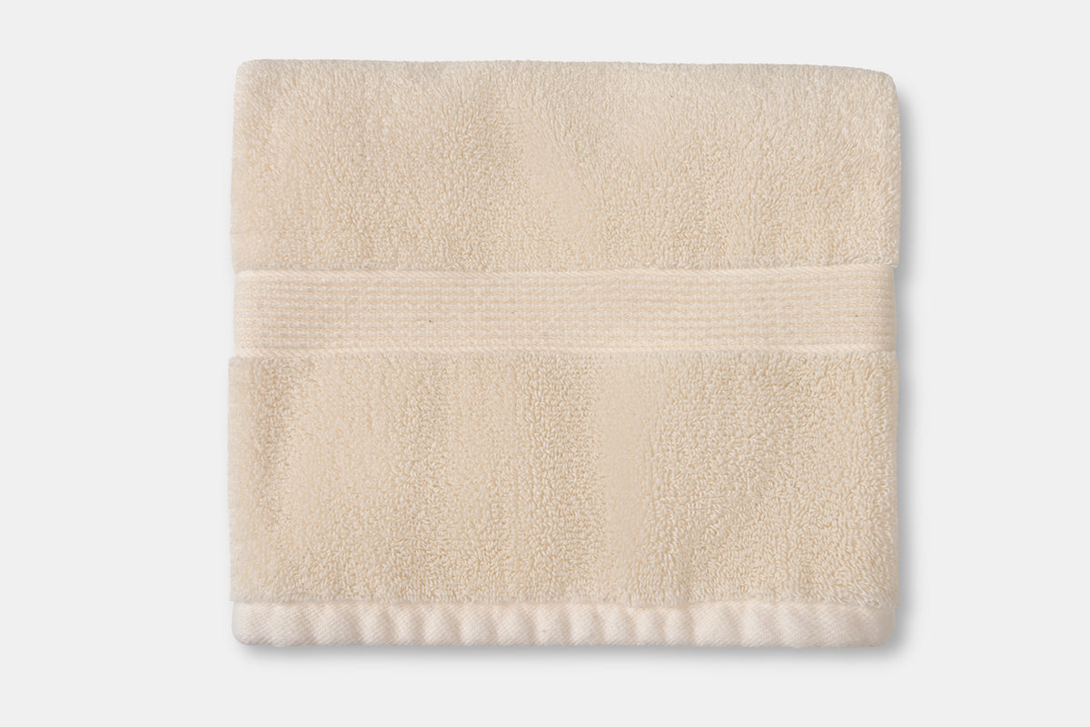 Stack of oversized luxury cotton bath towels in neutral beige