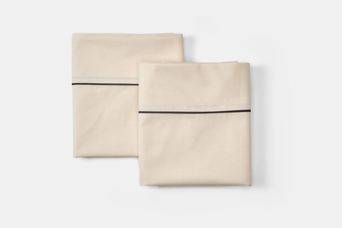 Cotton bed pillowcases with classic piping design in beige, made in USA