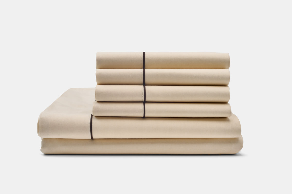 Cream with Brown Piping cotton bed sheet set with classic piping design, neatly folded